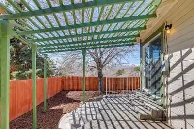 a green pergola on the side of a house at Gateway to Mt Rose Ski! Reno Home Near Casinos in Reno