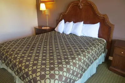 a hotel room with a large bed with white pillows at American Inn Stockton in Stockton