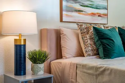 a lamp on a table next to a couch with pillows at Manic Mountain Forest Cabin 3 miles from Bass Lake in Oakhurst