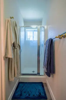 a shower with a glass door in a bathroom at Manic Mountain Forest Cabin 3 miles from Bass Lake in Oakhurst