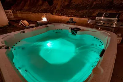 a jacuzzi tub in a room with a stove at Manic Mountain Forest Cabin 3 miles from Bass Lake in Oakhurst