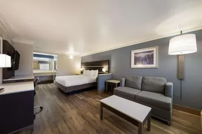 a living room with a bed and a couch and a room with a bed at Best Western Inn & Suites Lemoore in Lemoore