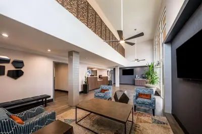 a living room with a couch and chairs and a tv at Best Western Inn & Suites Lemoore in Lemoore