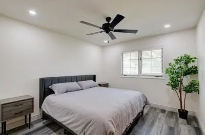 a bedroom with a bed and a ceiling fan at The Cedar Tree in Fresno