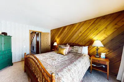 a bed in a bedroom with a wooden wall at Snowcreek 234 in Mammoth Lakes