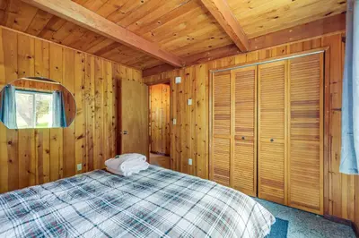 a bedroom with a bed in a wooden cabin at Groveland Vacation Rental about 24 Mi to Yosemite! in Groveland