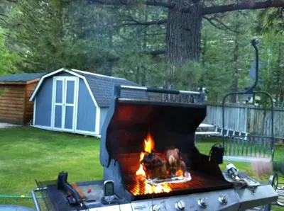 a barbecue grill with a fire in a yard at Tahoe Cottage perfect for couples and outdoor enthusiasts in South Lake Tahoe