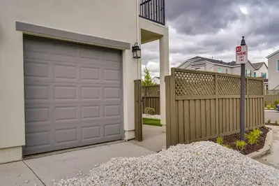 a house with a garage door and a pile of gravel at California Midterm Rental with Fenced Yard! in Tracy