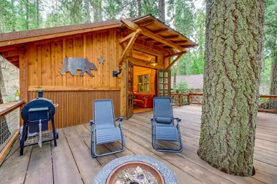 a cabin with chairs on a wooden deck at Creekside Cabin about 20 Mi to Kings Canyon Park! in Badger