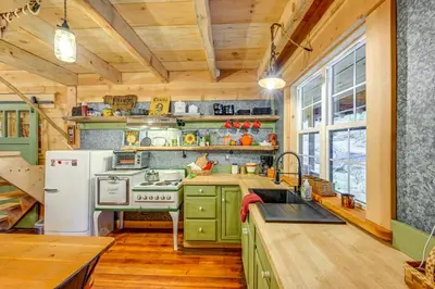 a kitchen with green cabinets and a white refrigerator at Creekside Cabin about 20 Mi to Kings Canyon Park! in Badger
