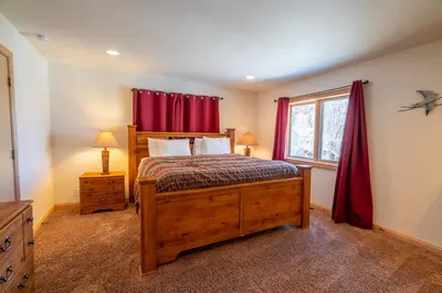 a bedroom with a bed and a window with red curtains at Rr-johnson Suite 2 in June Lake