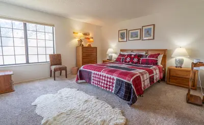 a bedroom with a bed and a chair and a window at Rr-interlaken 25 in June Lake