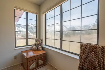 a teddy bear sitting on a table in a room with windows at Rr-interlaken 25 in June Lake
