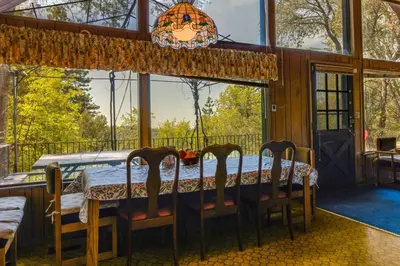 a dining room with a table and chairs and a large window at Hike, Bike and Golf Peaceful Cabin in Twain Harte! in Twain Harte