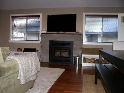 a living room with a fireplace with a flat screen tv at Elk House in June Lake