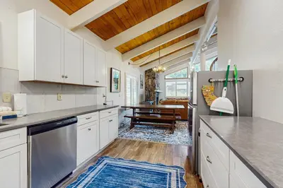 a kitchen with a refrigerator and a dining room at Saddle Road Sanctuary in South Lake Tahoe