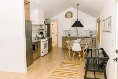 a kitchen with white cabinets and a table and chairs at Casita- Lake Area Winter Special Ends 51626 in Bass Lake