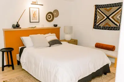 a bedroom with a large white bed and a chair at Casita- Lake Area Winter Special Ends 51626 in Bass Lake