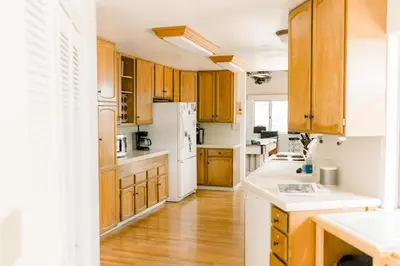 a kitchen with wooden cabinets and a white refrigerator at Moreno-Lake Area Free Night Special in Bass Lake