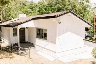 a white house with a porch at Moreno-Lake Area Free Night Special in Bass Lake