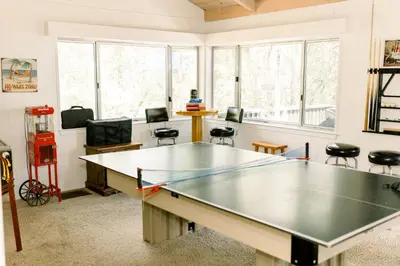 a ping pong table in a room with chairs at Moreno-Lake Area Free Night Special in Bass Lake