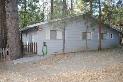 a white house with a fence and a tree at Cedar-Lake Area Winter Special Ends 51626 in Bass Lake