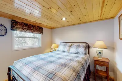 a bedroom with a bed and two lamps and a clock at Wilts Happy Place in Bass Lake