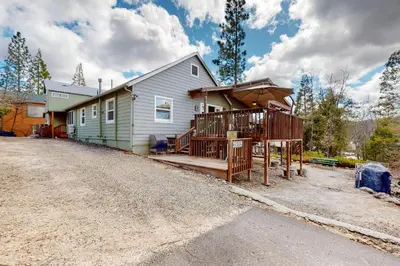 a house with a porch and a deck with an umbrella at Wilts Happy Place in Bass Lake