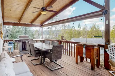 a patio with a table and chairs on a deck at Wilts Happy Place in Bass Lake