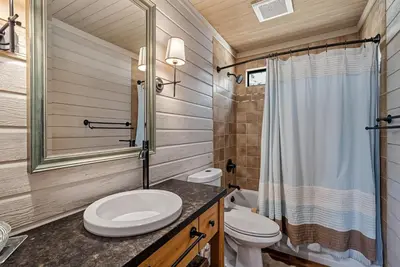 a bathroom with a toilet and a sink and a shower at Marina Beach Lodge - Lakefront Home on Beach! home in Groveland