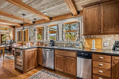 a kitchen with wooden cabinets and stainless steel appliances at Marina Beach Lodge - Lakefront Home on Beach! home in Groveland