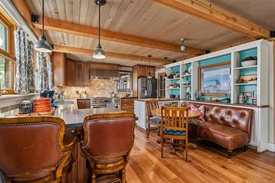 a kitchen with a couch and a table and chairs at Marina Beach Lodge - Lakefront Home on Beach! home in Groveland