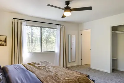 a bedroom with a ceiling fan and a window at Deck and Fire Pit Stunning Twain Harte Cabin! in Twain Harte