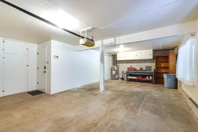 an empty garage with white walls and wood floors at Deck and Fire Pit Stunning Twain Harte Cabin! in Twain Harte