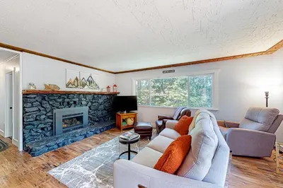 a living room with two couches and a fireplace at Casa de la Montaña in Bass Lake