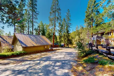 a house with a barn next to a road at Casa de la Montaña in Bass Lake