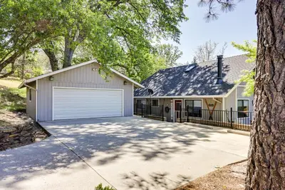 a house with a garage and a tree at Groveland Home - Walk to Pine Mountain Lake! in Groveland