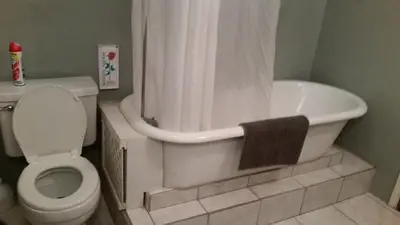 a bathroom with a tub and a toilet and a shower at The Parks Inn in Three Rivers
