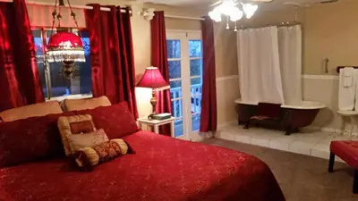 a living room with a red bed and a tub at The Parks Inn in Three Rivers