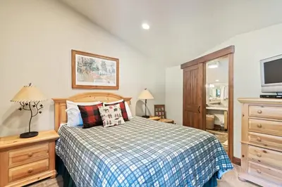 a bedroom with a bed and a dresser and a tv at Northstar Ski in Ski out 2BR Condo in Truckee