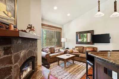 a living room with a fireplace and a couch at Northstar Ski in Ski out 2BR Condo in Truckee