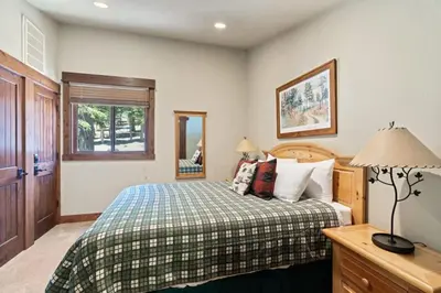 a bedroom with a bed and a table with a lamp at Northstar Ski in Ski out 2BR Condo in Truckee