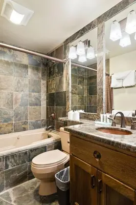 a bathroom with a toilet and a sink and a tub at Northstar Ski in Ski out 2BR Condo in Truckee