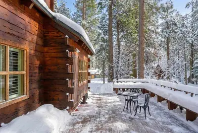 a cabin in the snow with a table and chairs at 3BR Mountain Cabin-Near Beach & Slopes in Homewood