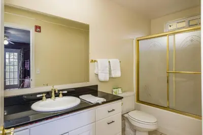 a bathroom with a sink and a toilet and a mirror at Yosemite South Presidential Mansion in Coarsegold