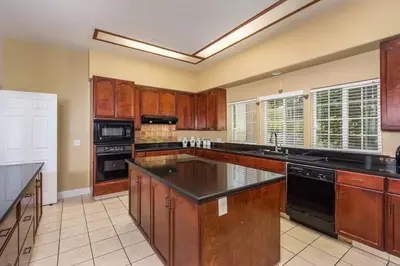 a large kitchen with wooden cabinets and black appliances at Yosemite South Presidential Mansion in Coarsegold