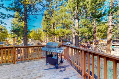 a grill on a wooden deck with trees at Heavenly Lake Hideaway in South Lake Tahoe