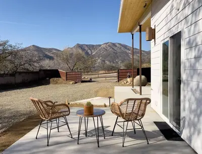 three chairs and a table on a patio with mountains at Eagle Rock Nest ～Quiet & Gorgeous Mountain Views in Three Rivers