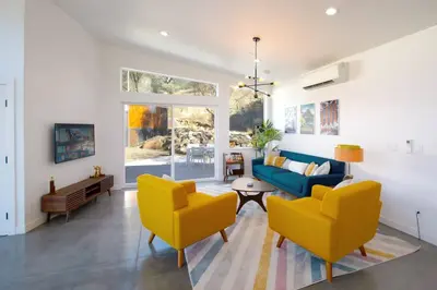 a living room with yellow chairs and a blue couch at Eagle Rock Nest ～Quiet & Gorgeous Mountain Views in Three Rivers