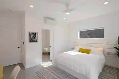 a white bedroom with a bed with a yellow pillow at Eagle Rock Nest ～Quiet & Gorgeous Mountain Views in Three Rivers